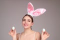 Close up photo of pretty girl wear easter fluffy bunny ears hold easter eggs, isolated studio background. Eater portrait
