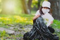 Close up photo of a pretty laughing girl in a medical mask putting into a garbage bag a paper with recycle sign drown on Royalty Free Stock Photo