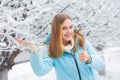 Close up photo of pretty young woman standing smiling in the snowy winter forest showing thumb up gesture Royalty Free Stock Photo