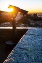 A close up photo of a public monocular on the top of a mountain with spectacular aerial views of the old city of Verona in Italy.