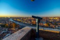 A close up photo of a public monocular on the top of a mountain with spectacular aerial views of the old city of Verona in Italy.