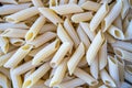 Close up photo of raw penne pasta.