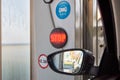 Close-up photo of a rear-view mirror inside a car wash with water drops, a symbol and a red shining STOP sign