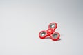 Close-up photo of a red fidget spinner on a white background. Royalty Free Stock Photo