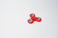 Close-up photo of a red fidget spinner on a white background. Royalty Free Stock Photo