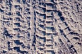 Close-up photo of a road in the winter season. On the dirty snow, a protector is visible from the tires of the truck
