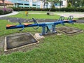 Close up photo of seasaw children playground with green surrounding it