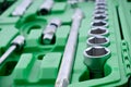 Chrome mechanics tools set. Close-up photo of a set of sockets with a screwdriver and a ratchet in a green plastic case against a Royalty Free Stock Photo