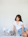 Photo of a sexy brunette working at the sewing machine and playing with a gray kitten Royalty Free Stock Photo