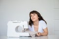 Photo of a sexy brunette working at the sewing machine Royalty Free Stock Photo