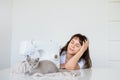 Photo of a sexy brunette working at the sewing machine and playing with a gray kitten Royalty Free Stock Photo