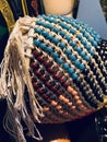 Close up photo of shekere, beaded in turquoise, black, and tangerine beads