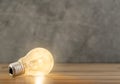 Close up photo of shining single light bulb on green blurred background Royalty Free Stock Photo