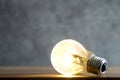 Close up photo of shining single light bulb on green blurred background Royalty Free Stock Photo