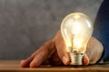 Close up photo of shining single light bulb on green blurred background Royalty Free Stock Photo