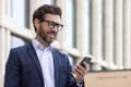 Close-up photo of a smiling young man businessman, lawyer, politician wearing a suit and glasses standing outside an Royalty Free Stock Photo