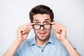 Close up photo of speechless man shocked with his eyesight corrected with new eyewear isolated over grey color