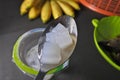 Close up photo of a spon of sweet jelly drink with a hand of banana in the background