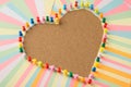 Close up photo of stickers and pins making shape of heart on the wooden board with empty space in center Royalty Free Stock Photo