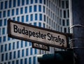 A close up photo of a street sign with the German name Budapester Strasse, mounted on a lamp post in the city center called KurfÃÂ¼ Royalty Free Stock Photo