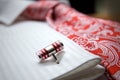 Close-up photo of stud on white shirt with red tie