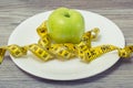 Close up photo of tape measure coiled around an apple on white p Royalty Free Stock Photo