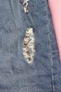 Close-up photo of torn blue jeans. Ripped denim blue cloth background Royalty Free Stock Photo