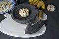 Close up of traditional kitchen utensil: the stone plate or stone mortar with gralic bulb