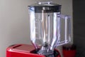 Transparent plastic blender bowl on a red kitchen processor