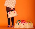 Close up photo of trendy violet bag with fur trinket in hands of fashionable woman posing in street with blooming spring Royalty Free Stock Photo