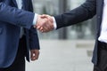 Close-up photo, two businessmen greet each other and shake hands, colleagues from outside