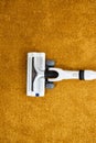 Close-up photo of vacuum cleaner applied on yellow carpet at home removing dust Royalty Free Stock Photo