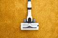 Close-up photo of vacuum cleaner applied on yellow carpet at home removing dust Royalty Free Stock Photo