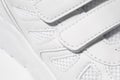 A close-up photo of the Velcro fastener of sneakers. Macro photo of children's sports white sneakers made of leather
