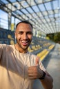 Close-up photo. Vertical photo. Young African American male sportsman stands in headphones at the stadium, takes a