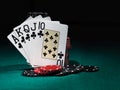 Winning combination in poker standing leaning on chips piles on green cover of playing table. Black background. Close-up Royalty Free Stock Photo