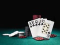 Winning combination in poker standing leaning on multicolored chips piles on green cover of playing table. Black Royalty Free Stock Photo