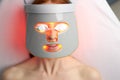 Close-up photo of woman getting photodynamic face mask therapy