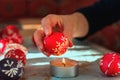 Close up photo of woman hand remove wax from easter egg with candle fire. Tradition method of painting