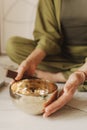 Close up photo of woman hands holding playing on Tibetan singing bowl while sitting on yoga mat. Vintage tonned. Soft focus, Royalty Free Stock Photo