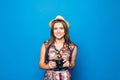 Close up of woman in hat on blue background taking a photo with digital camera Royalty Free Stock Photo