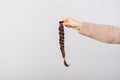 Close up photo of woman holding braided brown hair for donation