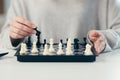 Close-up photo of a woman`s hands making a move in a game of chess