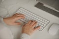 Close-up photo of womanÃ¢â¬â¢s hands typing on a wireless white aluminum keyboard Royalty Free Stock Photo