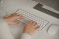 Close-up photo of womanÃ¢â¬â¢s hands typing on a wireless white aluminum keyboard Royalty Free Stock Photo