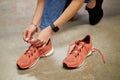 Close-up photo of woman tying shoelaces on sneakers