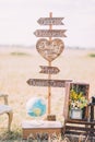 The close-up photo of the wooden plaque with the signs ``Wedding, photo, dancing`` standing near rge globe and wooden