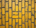 Close up photo of yellow brick wall. Rectangular paving stones pattern creates texture. Ancient background shows urban design. Royalty Free Stock Photo