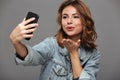 Close-up photo of young attractive woman sending air kiss while Royalty Free Stock Photo