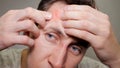 Close up photo of young man looking for acnes on his face Royalty Free Stock Photo